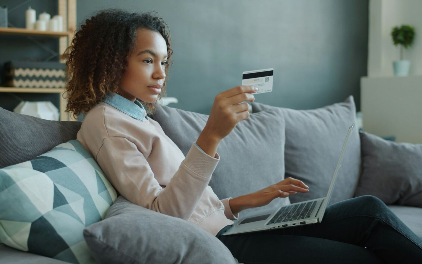 Shopper on her sofa paying for an online order on her laptop