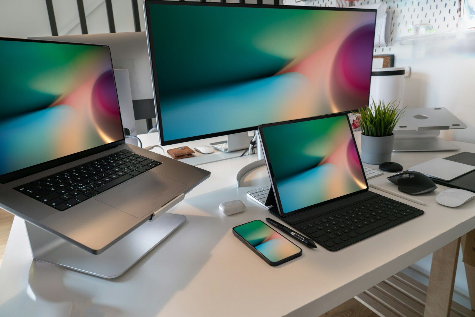 A laptop, desktop monitor, tablet and smartphone side by side on a bright desk