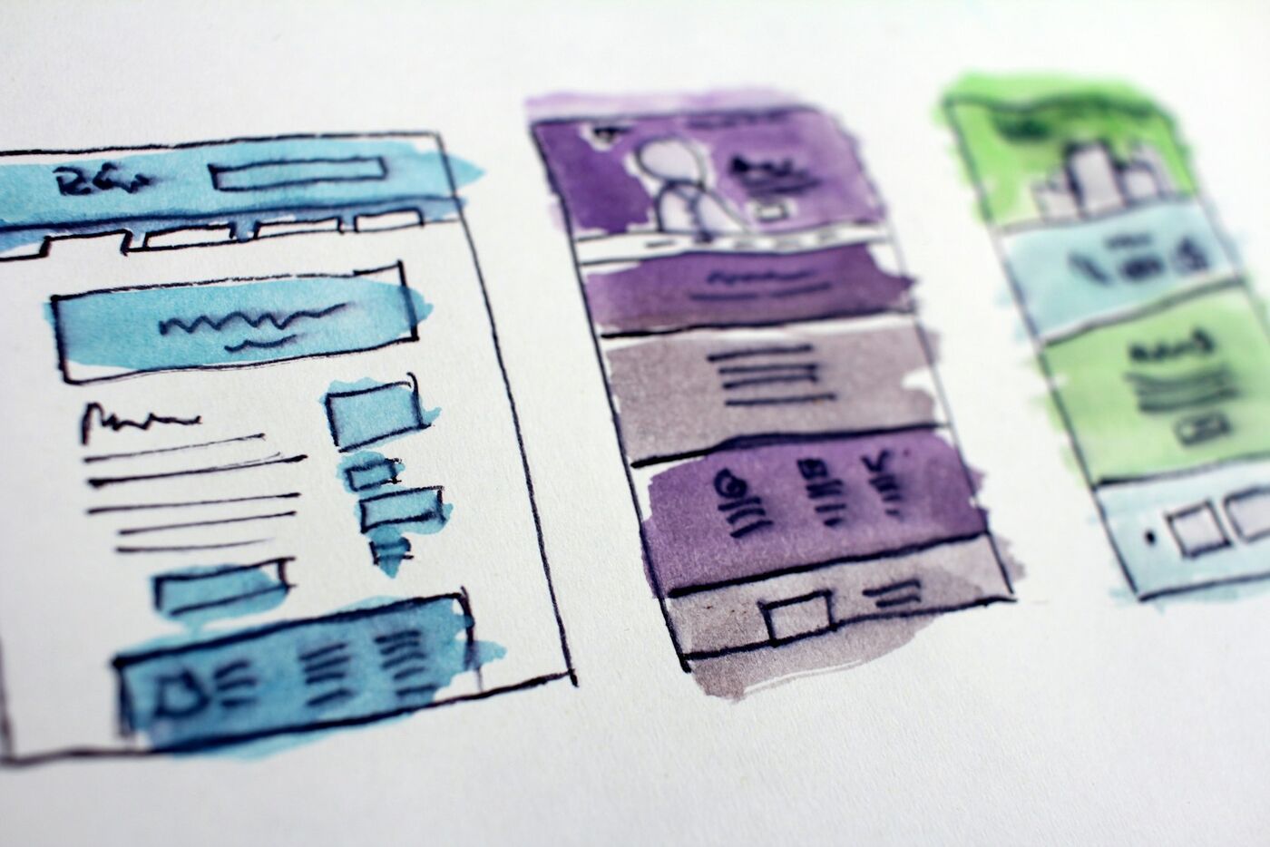 Hand-drawn watercolour wireframes of desktop and mobile website layouts