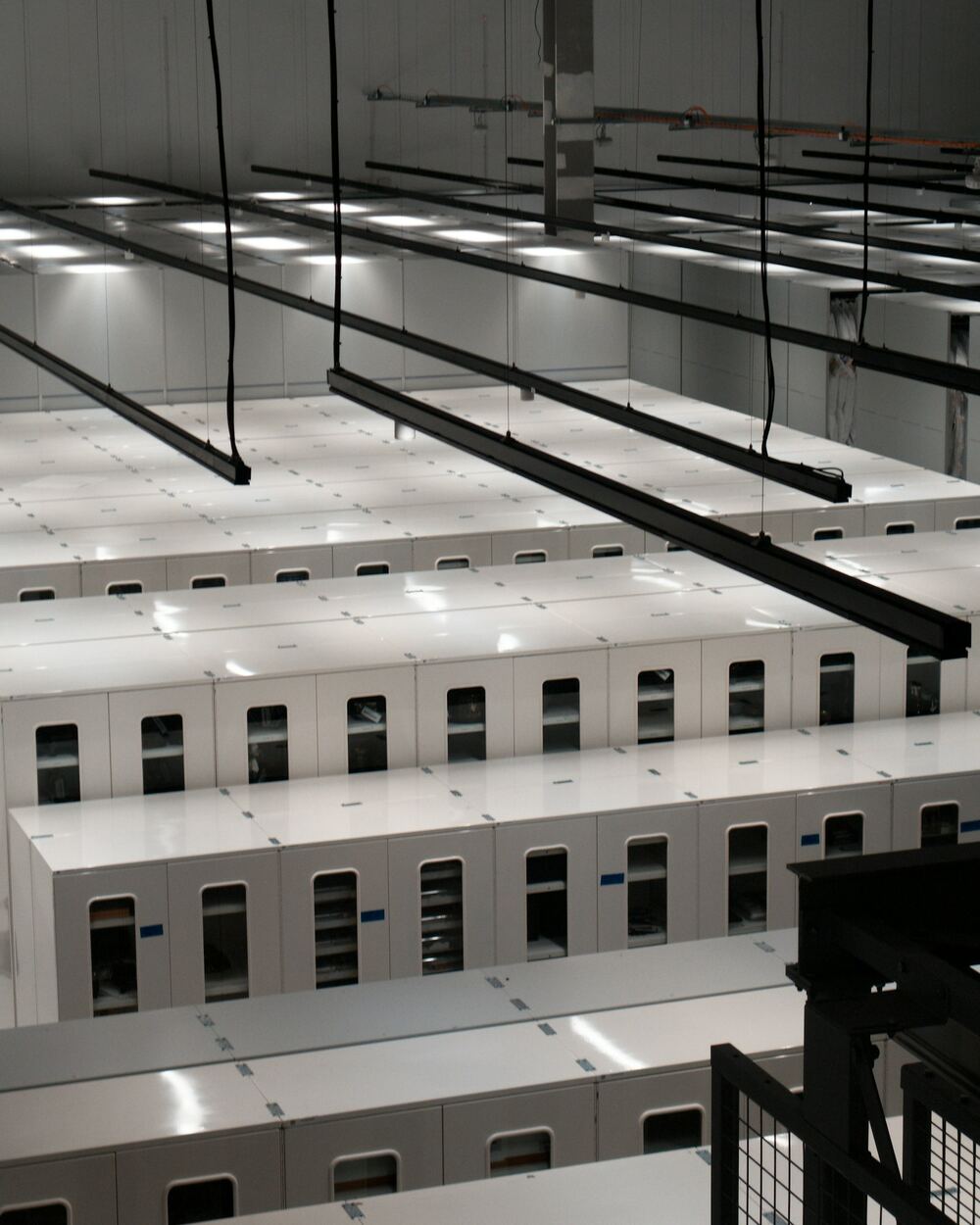 Rows of white server cabinets in a bright, modern data centre
